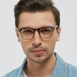 A man wearing glasses and a denim jacket