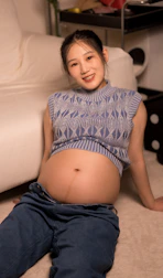 A pregnant woman is sitting on the floor
