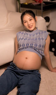 A pregnant woman is sitting on the floor