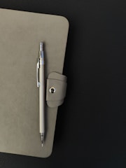 A notepad with a pen on top of it