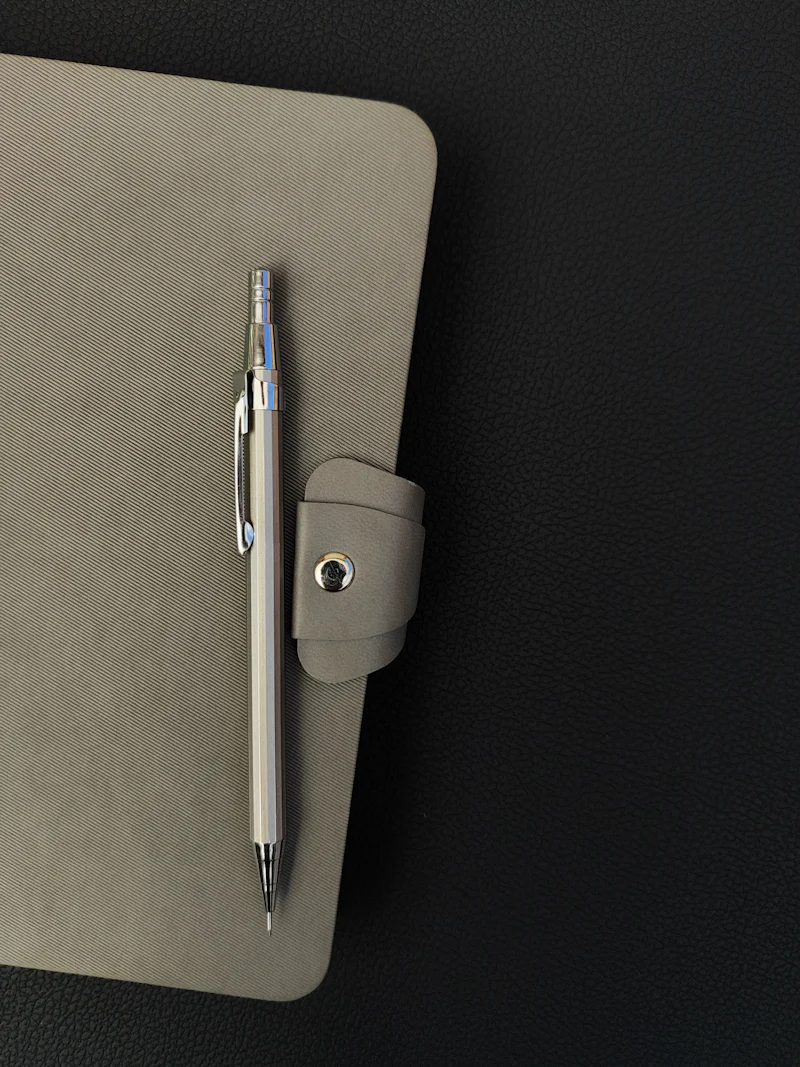 A notepad with a pen on top of it