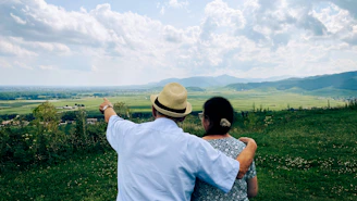 A man and a woman standing on top of a lush green field