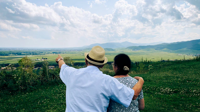 A man and a woman standing on top of a lush green field