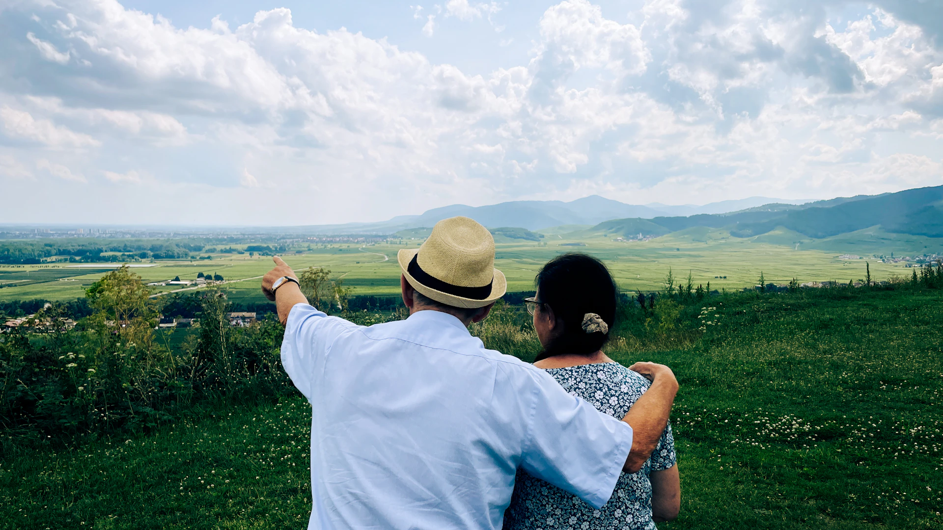 A man and a woman standing on top of a lush green field