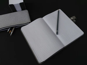 A notebook with a pen on top of it
