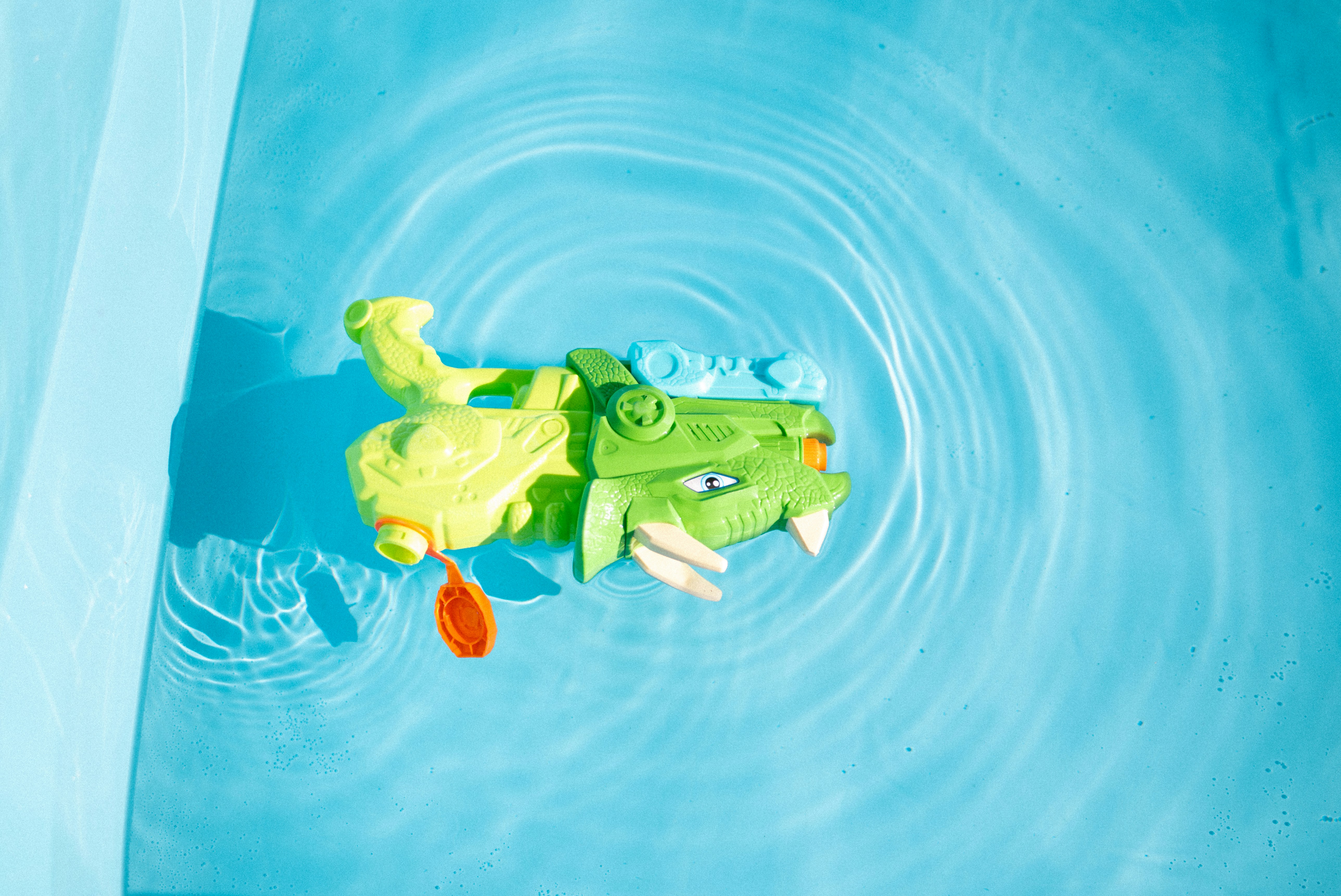 A toy alligator swimming in a pool of water