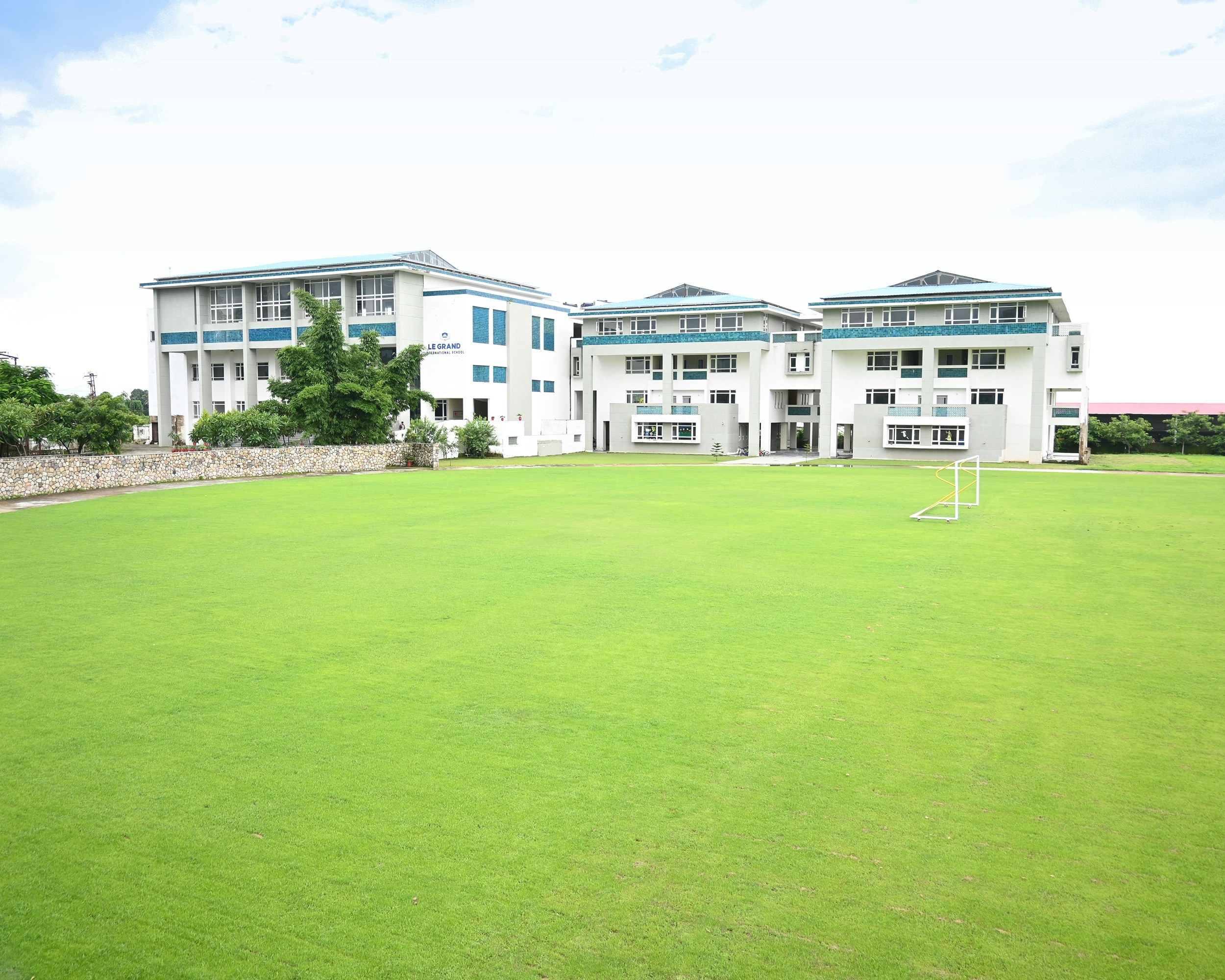 A soccer field in front of a row of apartment buildings