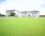 A soccer field in front of a row of apartment buildings