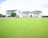 A soccer field in front of a row of apartment buildings