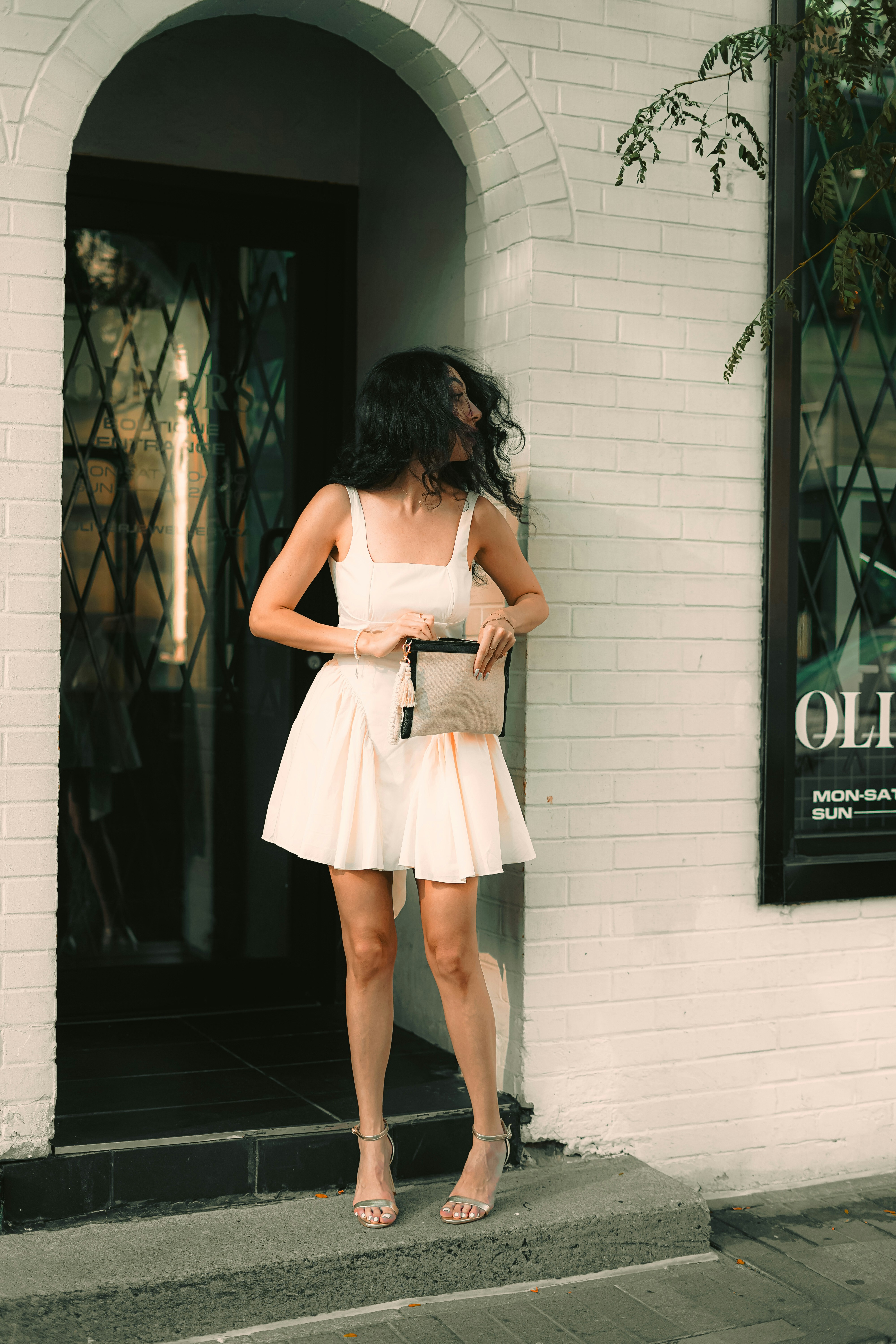 A woman standing in front of a white building