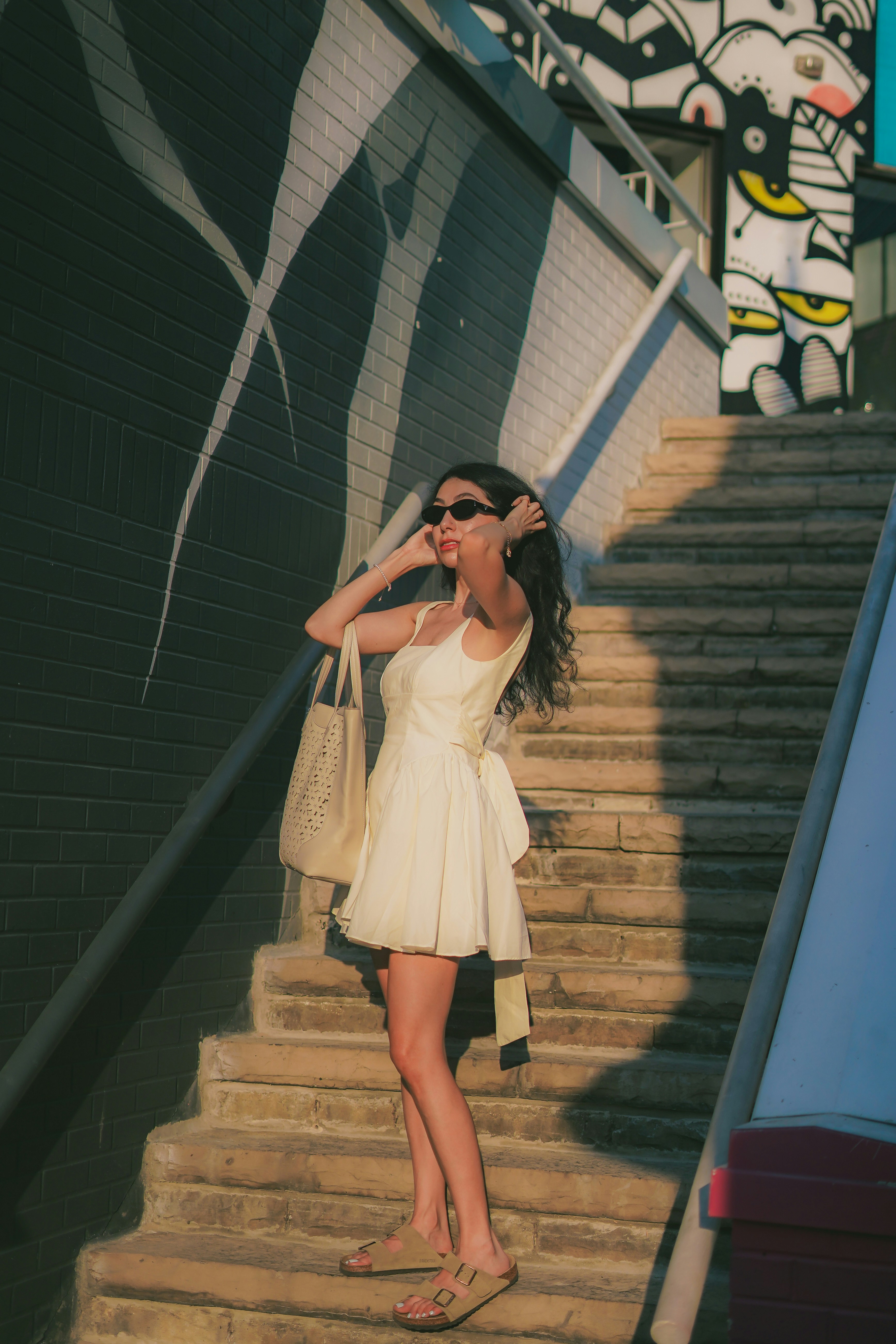 A woman in a white dress is standing on a set of stairs