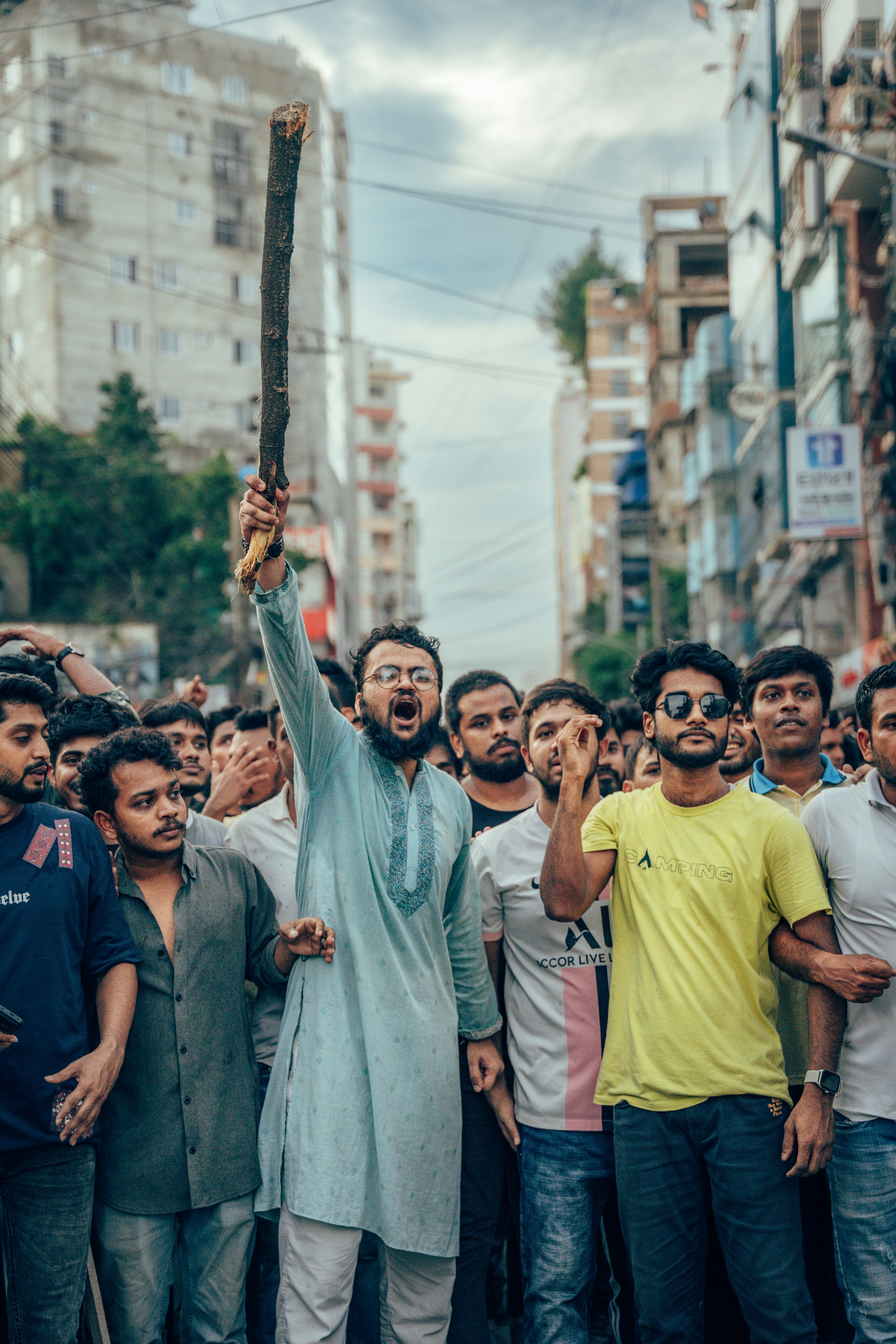 A group of people standing around a man holding a cross