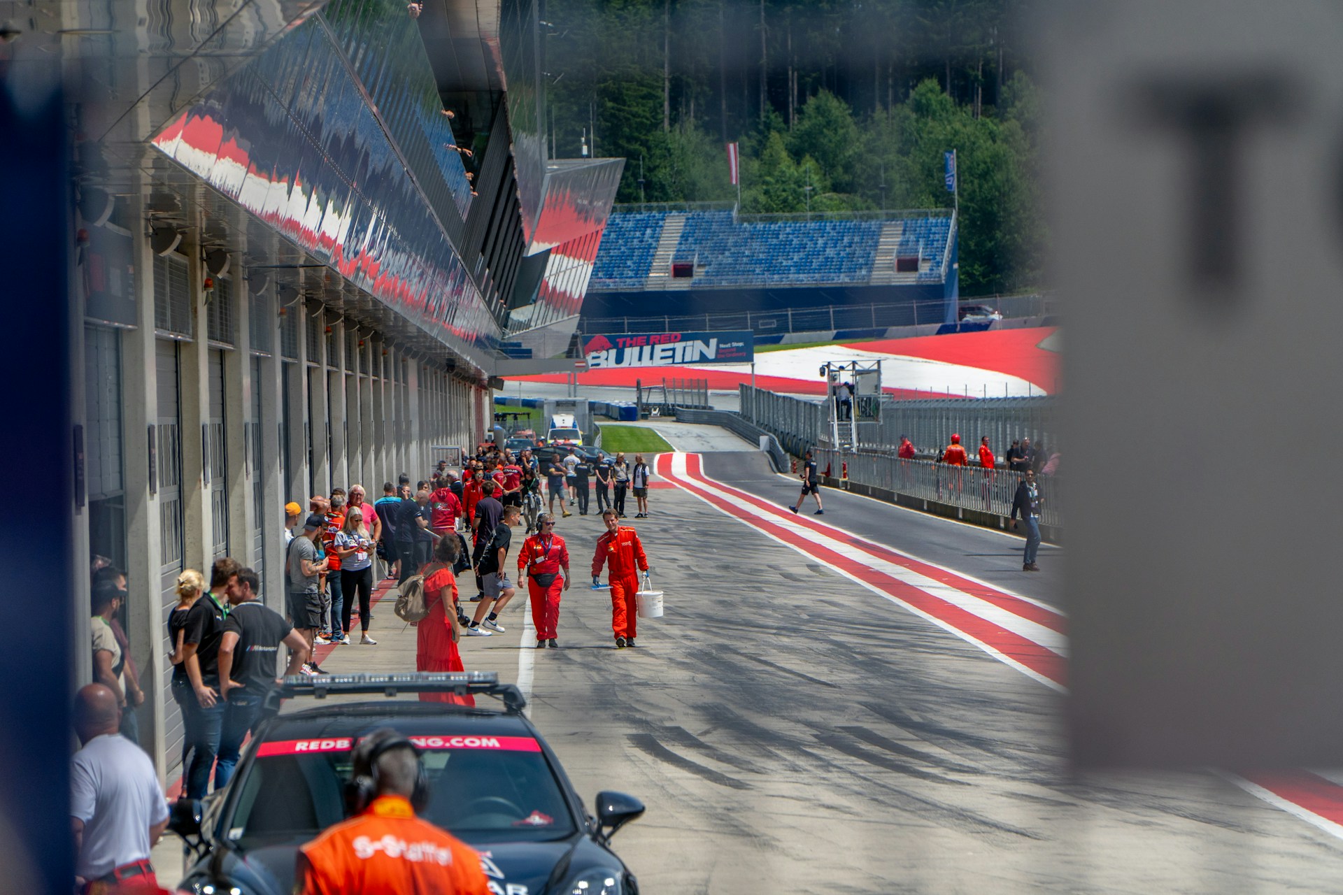 A group of people walking down a street next to a race track