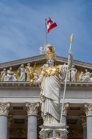 A statue of a woman holding a flag in front of a building