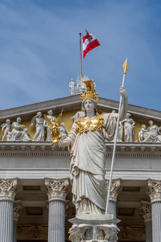 A statue of a woman holding a flag in front of a building