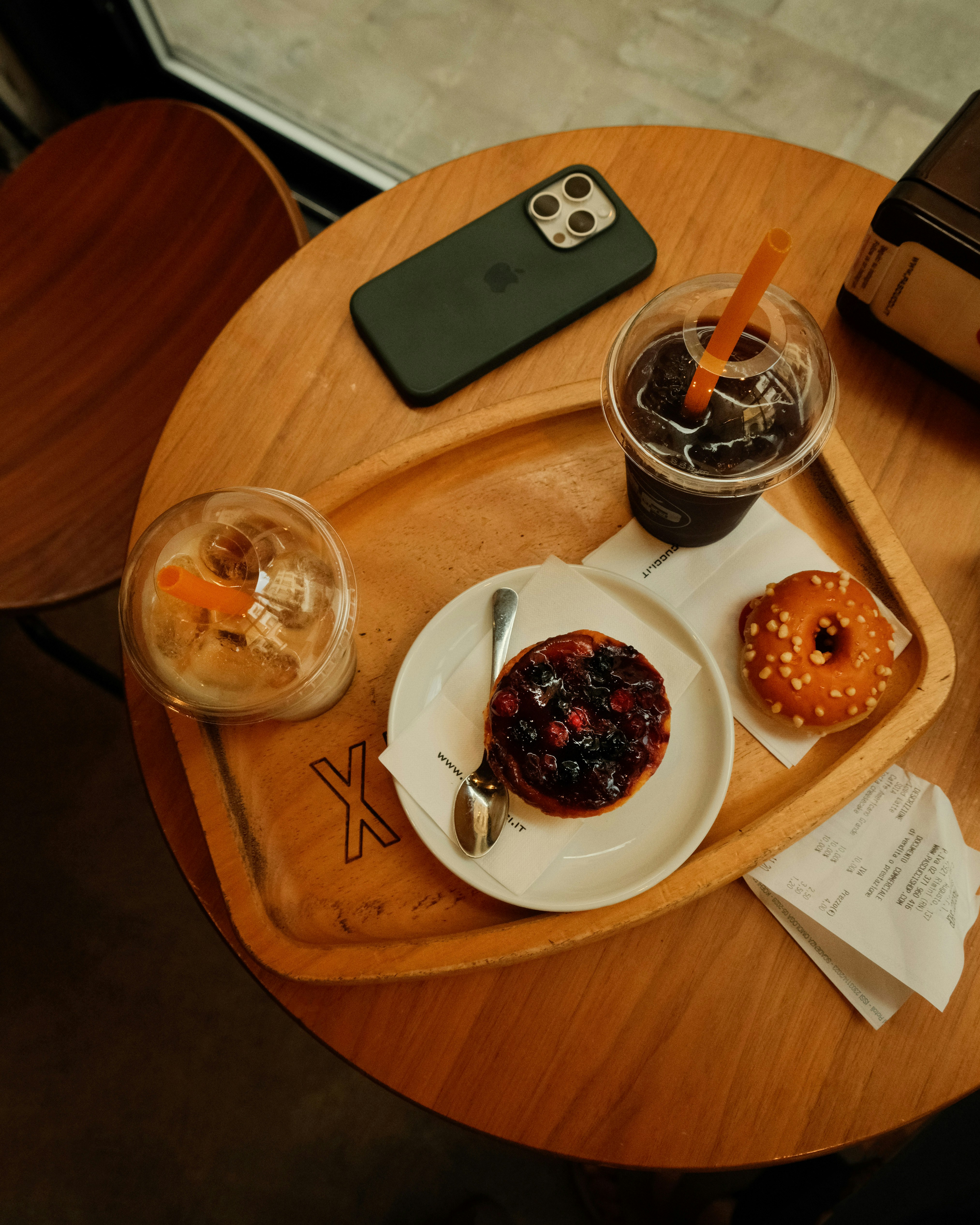 A wooden table topped with a plate of donuts