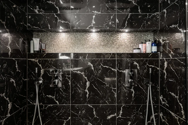 A bathroom with a black and white marble shower