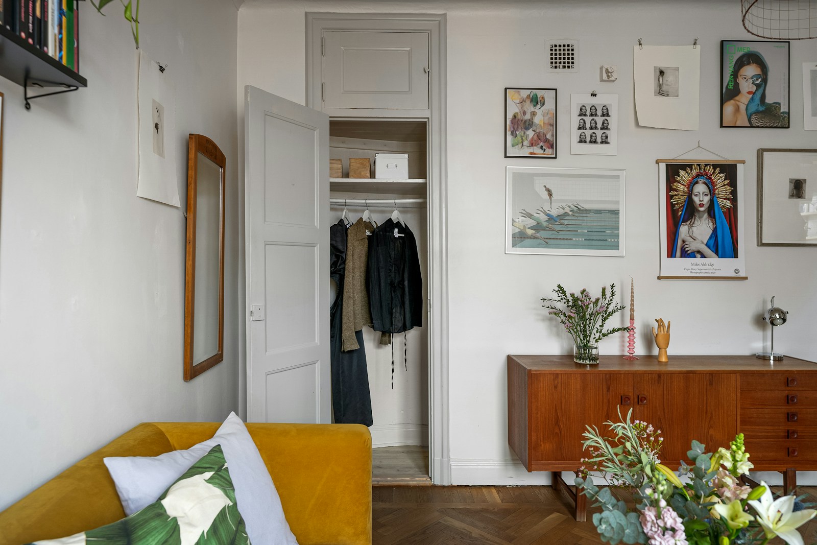 studio apartment closet open with art gallery wall and sideboard