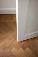 A white door is open on a wooden floor