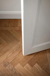 A white door is open on a wooden floor