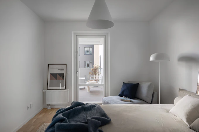Large white-walled bedroom with natural light