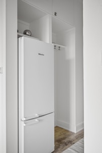 A white refrigerator freezer sitting inside of a kitchen