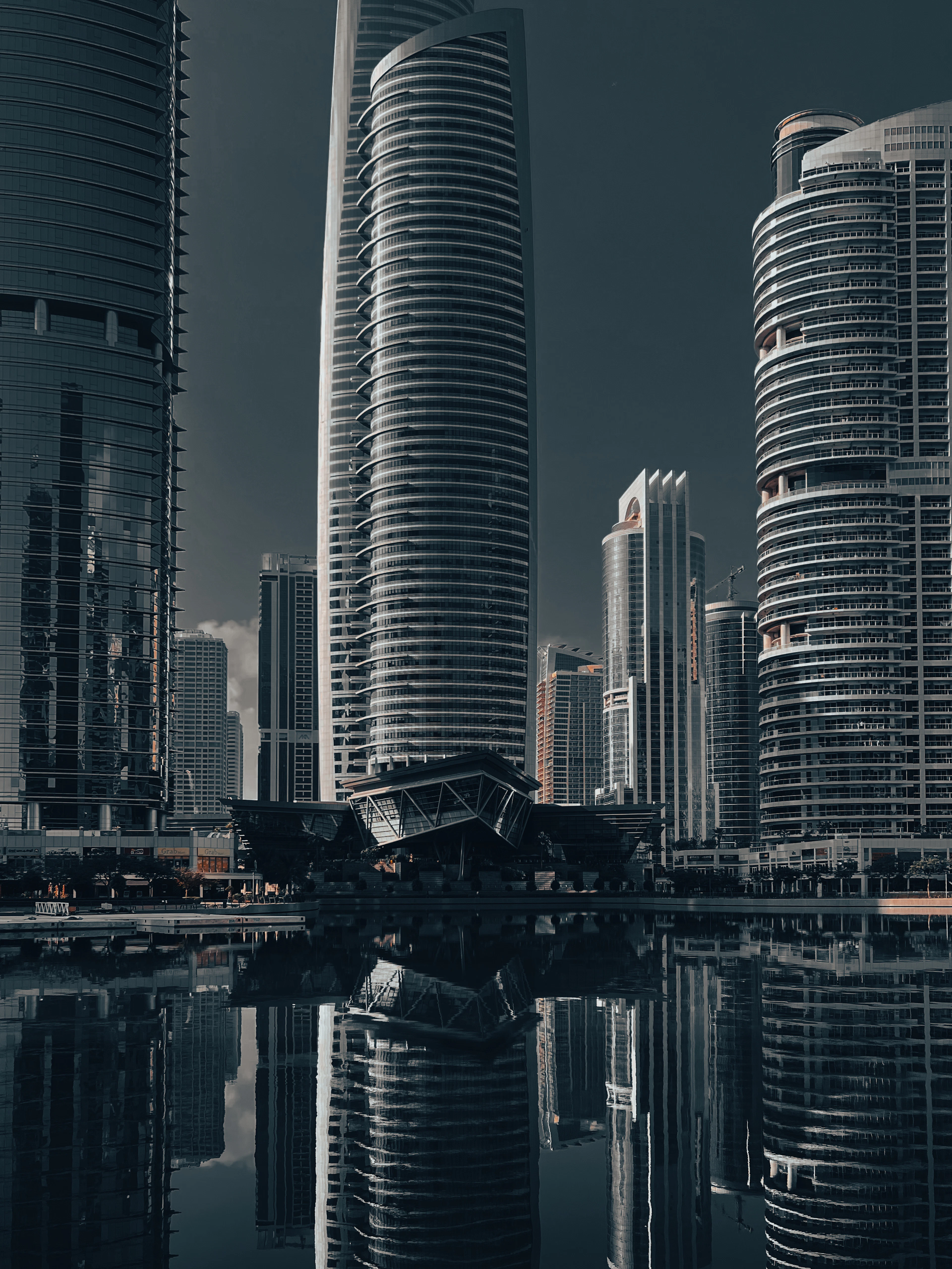 Glass towers rising beside one of the lakes in JLT