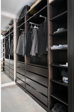 A walk in closet filled with lots of clothes