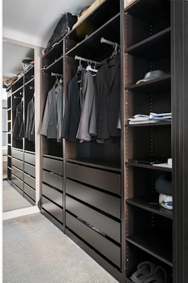 A walk in closet filled with lots of clothes