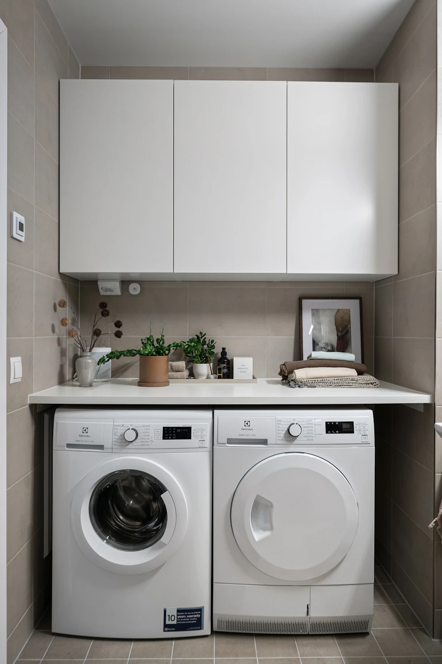 Home washing machine and dryer appliances in a laundry room