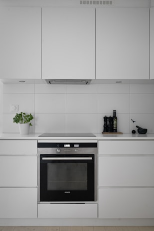 A kitchen with white cabinets and a black oven