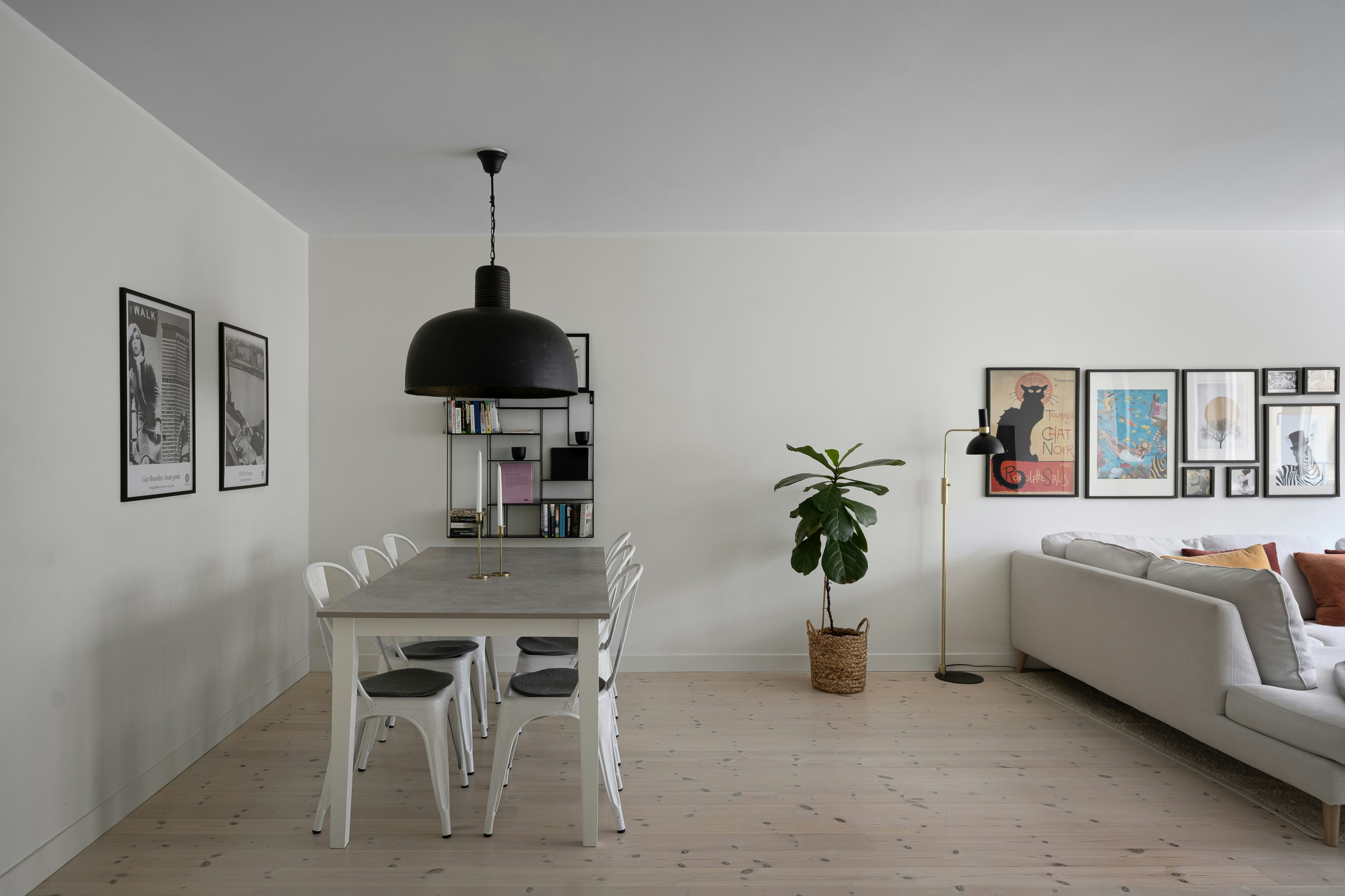 A living room with a couch a table and pictures on the wall