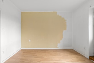 An empty room with a wooden floor and white walls