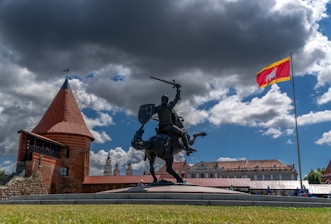 A statue of a man on a horse in front of a building