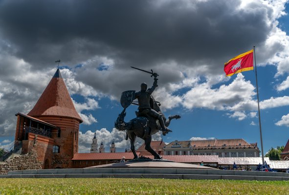 A statue of a man on a horse in front of a building — Kaunas, Lithuania
