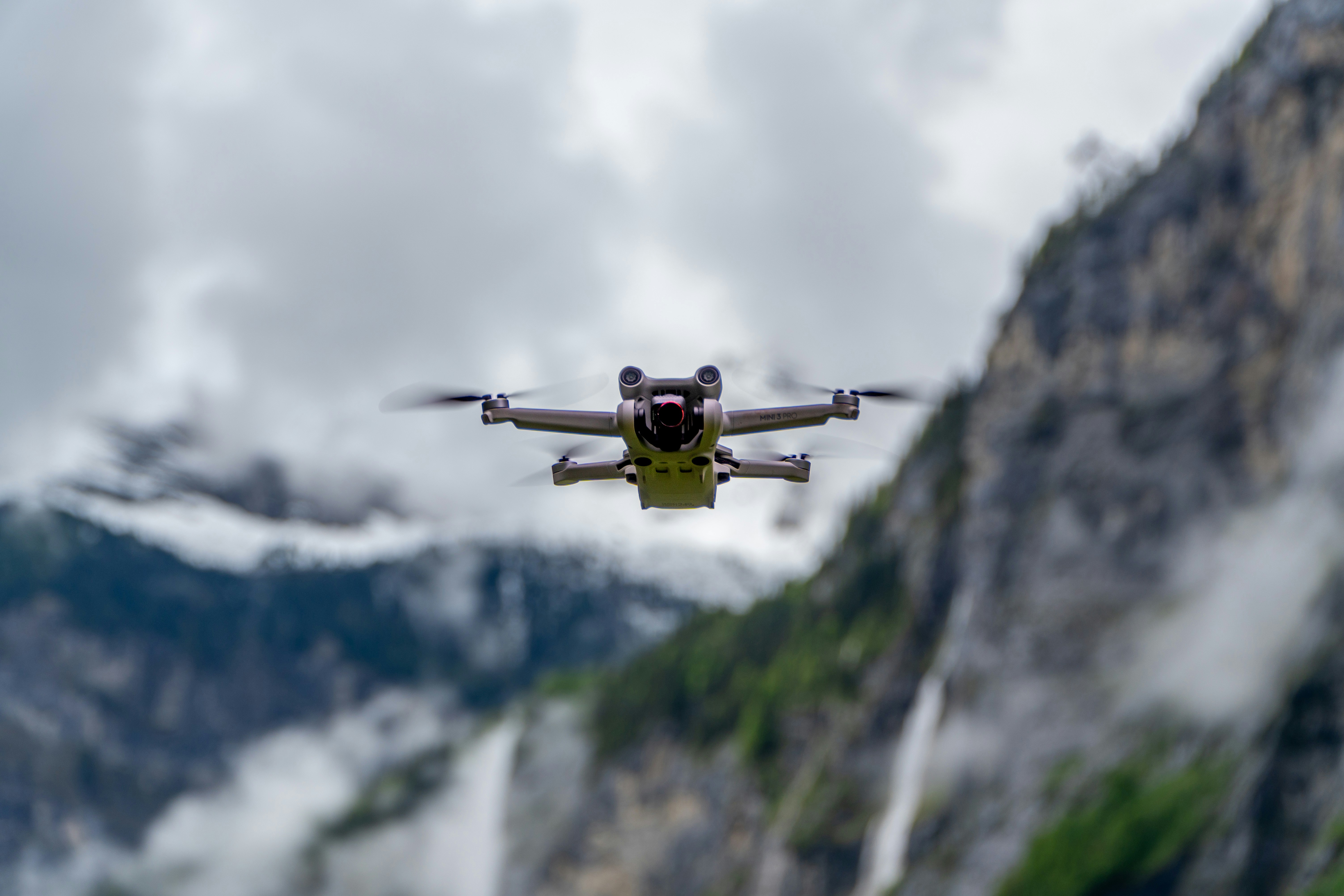 A small propeller plane flying over a mountain