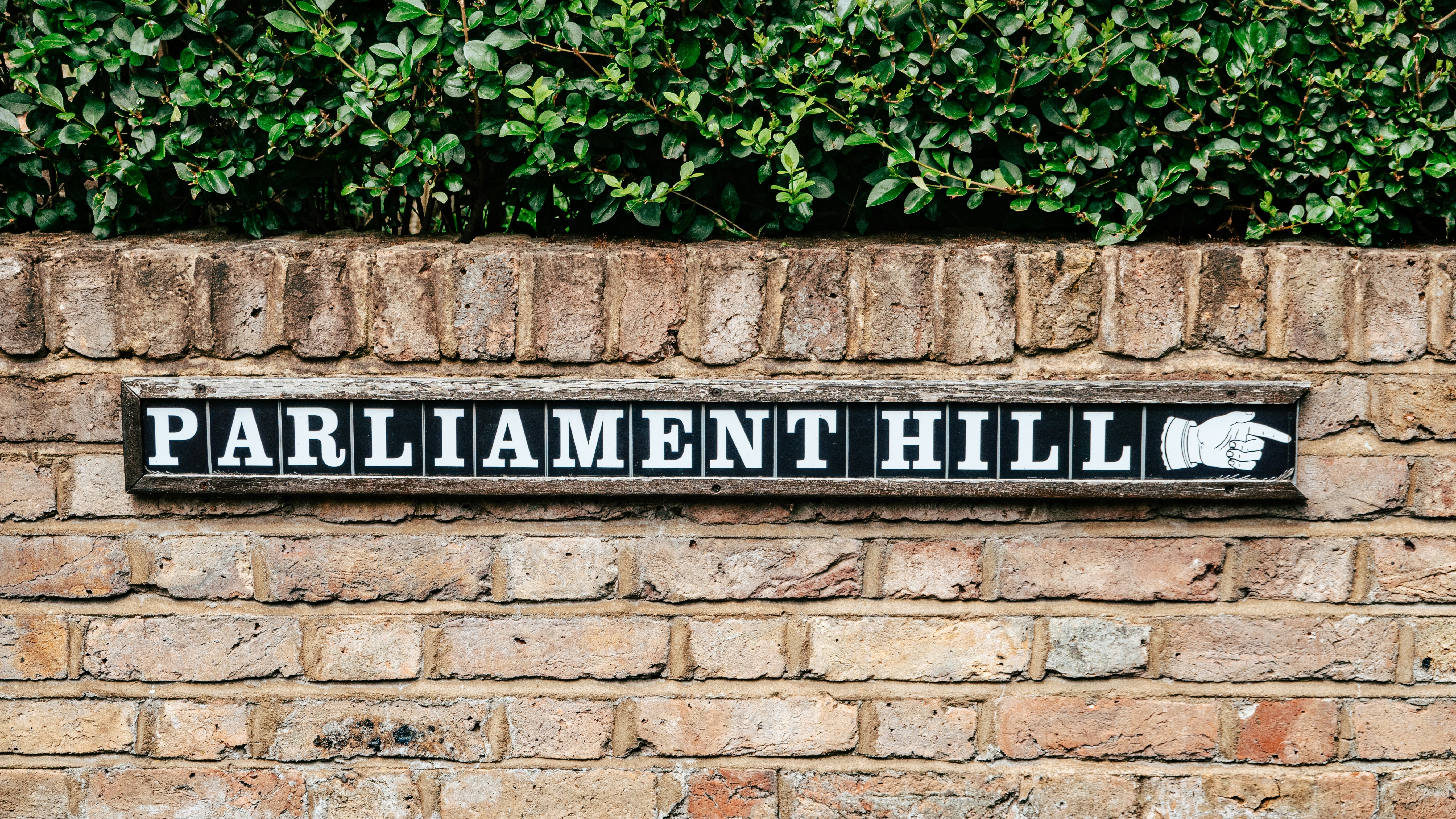 A brick wall with a sign that says parliament hill