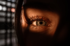 A close up of a person's eye with a keyboard in the background
