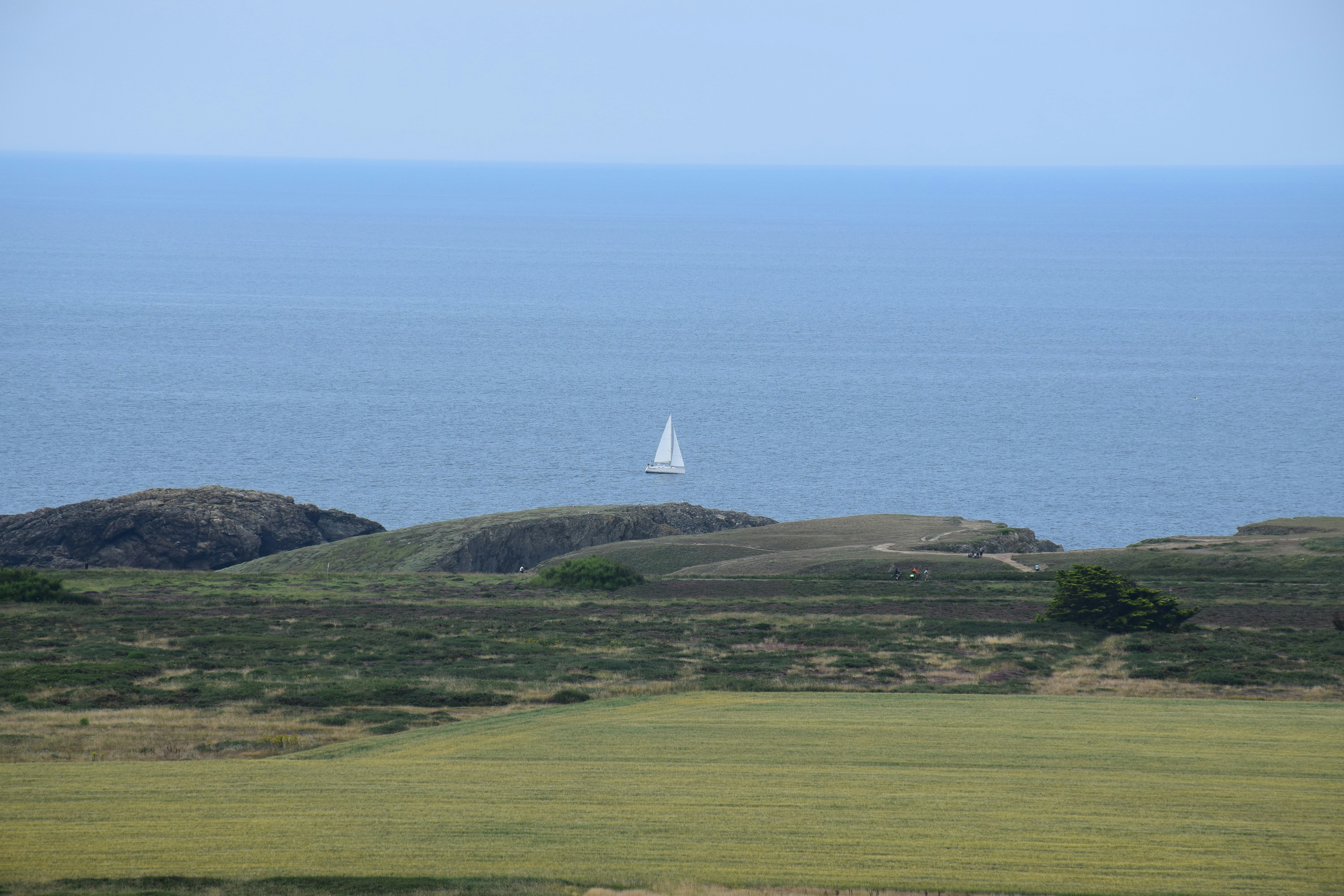 Une vue sur l’océan et un voilier au loin