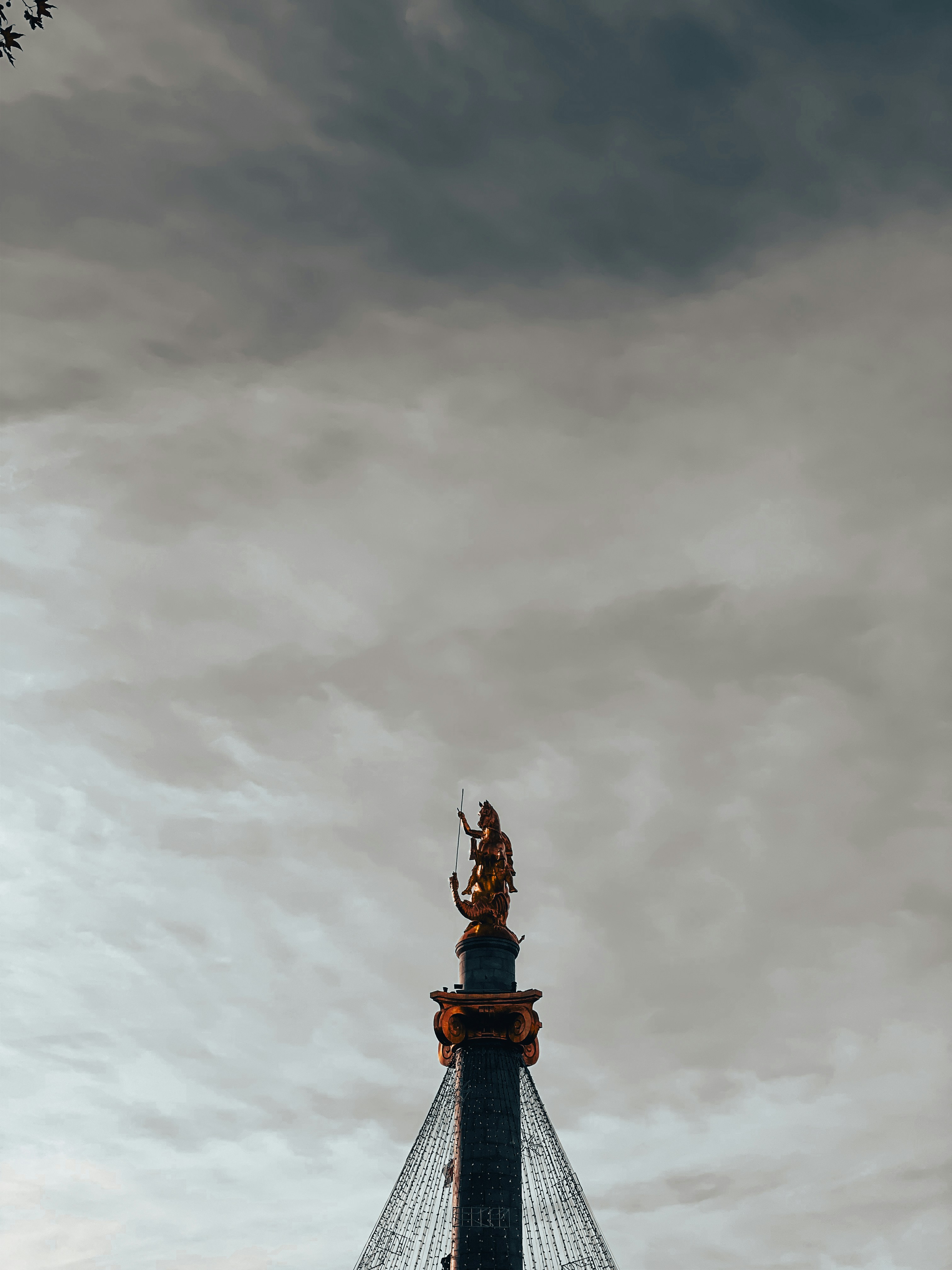A tall tower with a statue on top of it