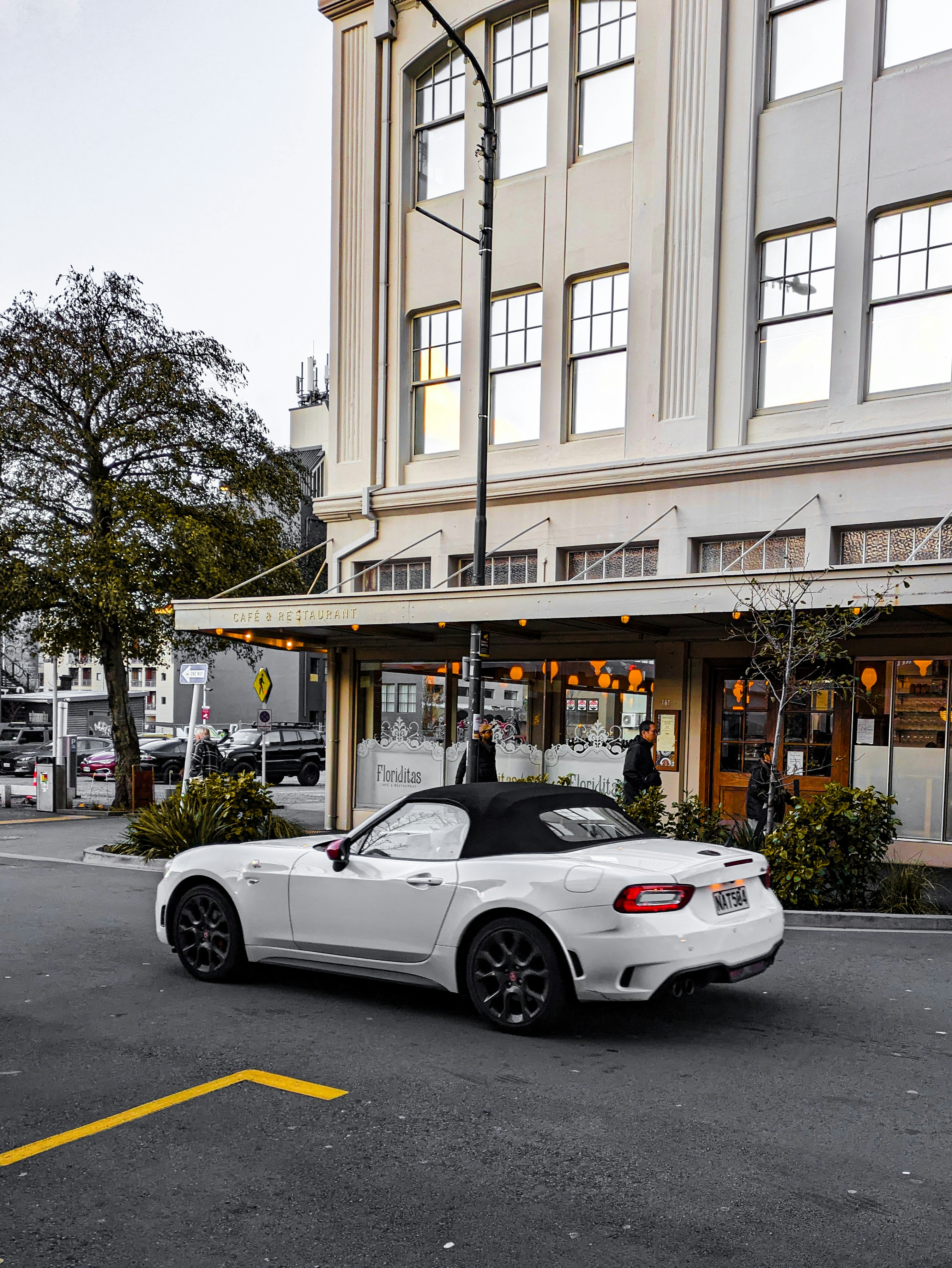 Ein weißer Sportwagen, der vor einem Gebäude parkt