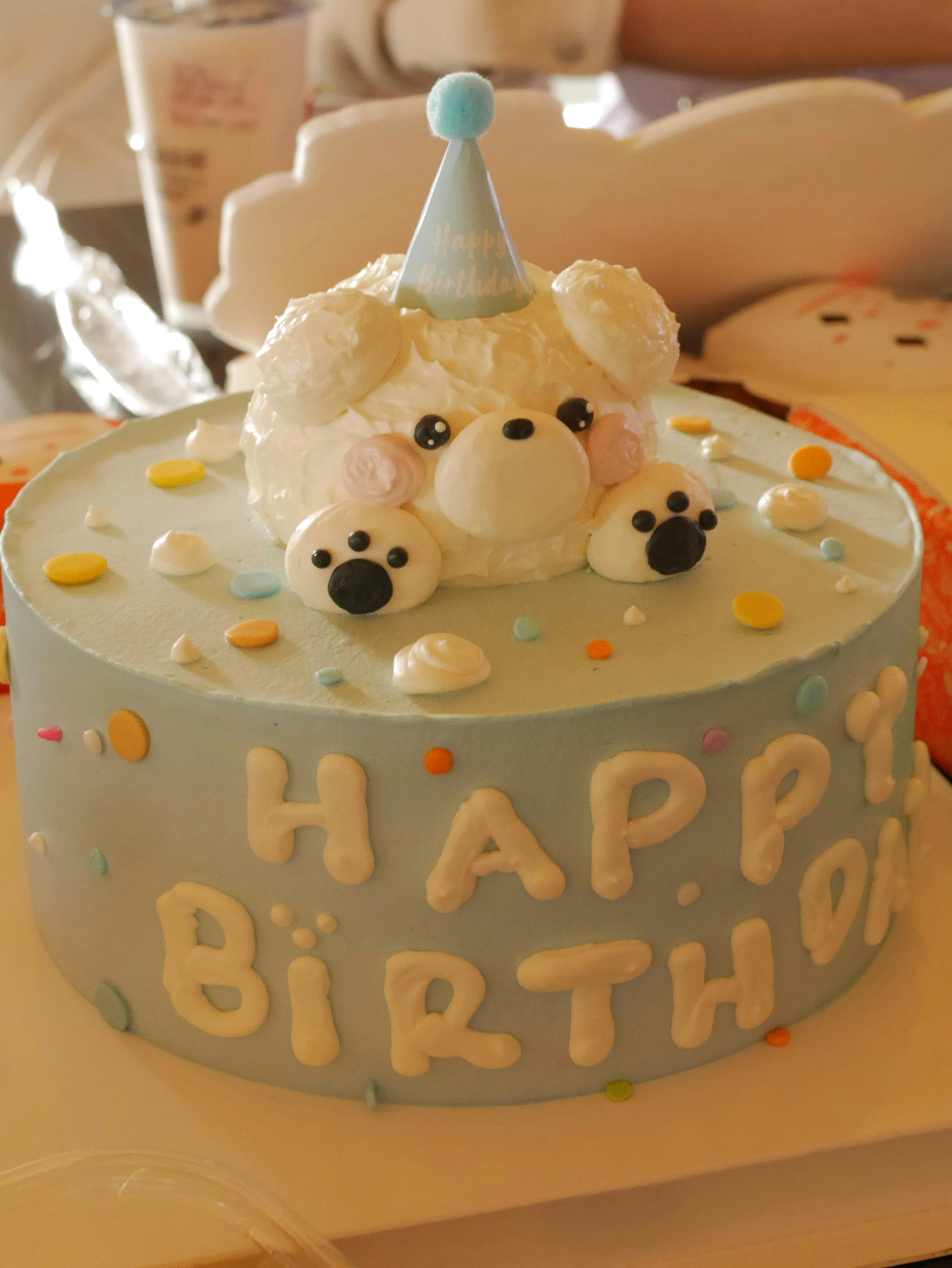 A birthday cake with a teddy bear on top of it