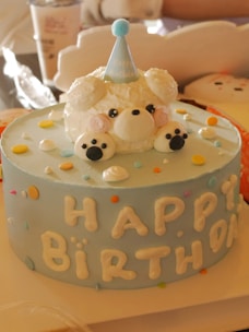 A birthday cake with a teddy bear on top of it