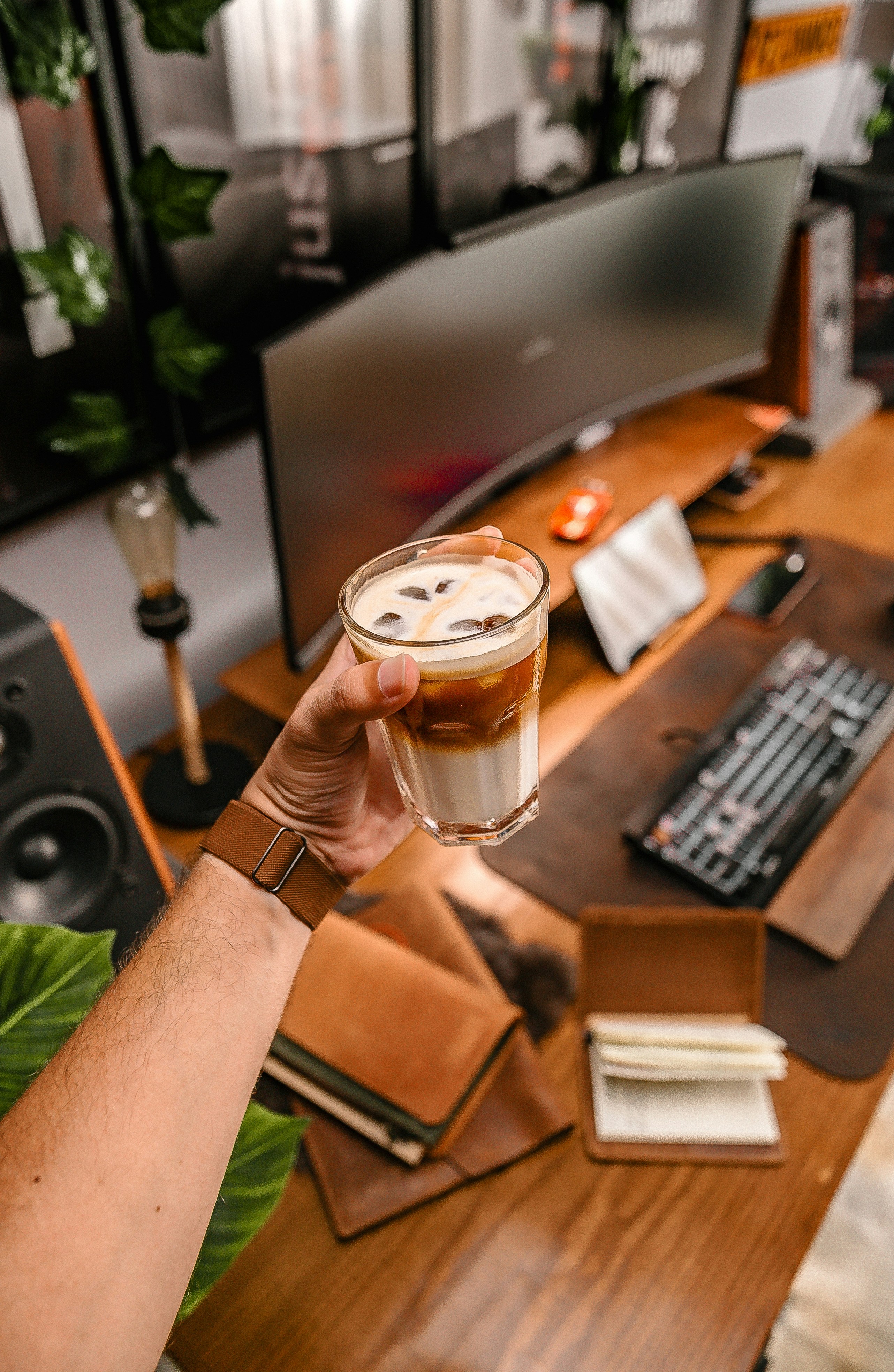 Una persona sosteniendo una bebida frente a una computadora