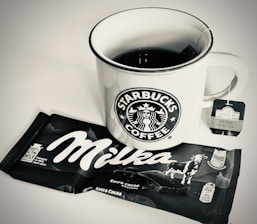 A cup of coffee next to a bag of coffee