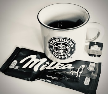 A cup of coffee next to a bag of coffee