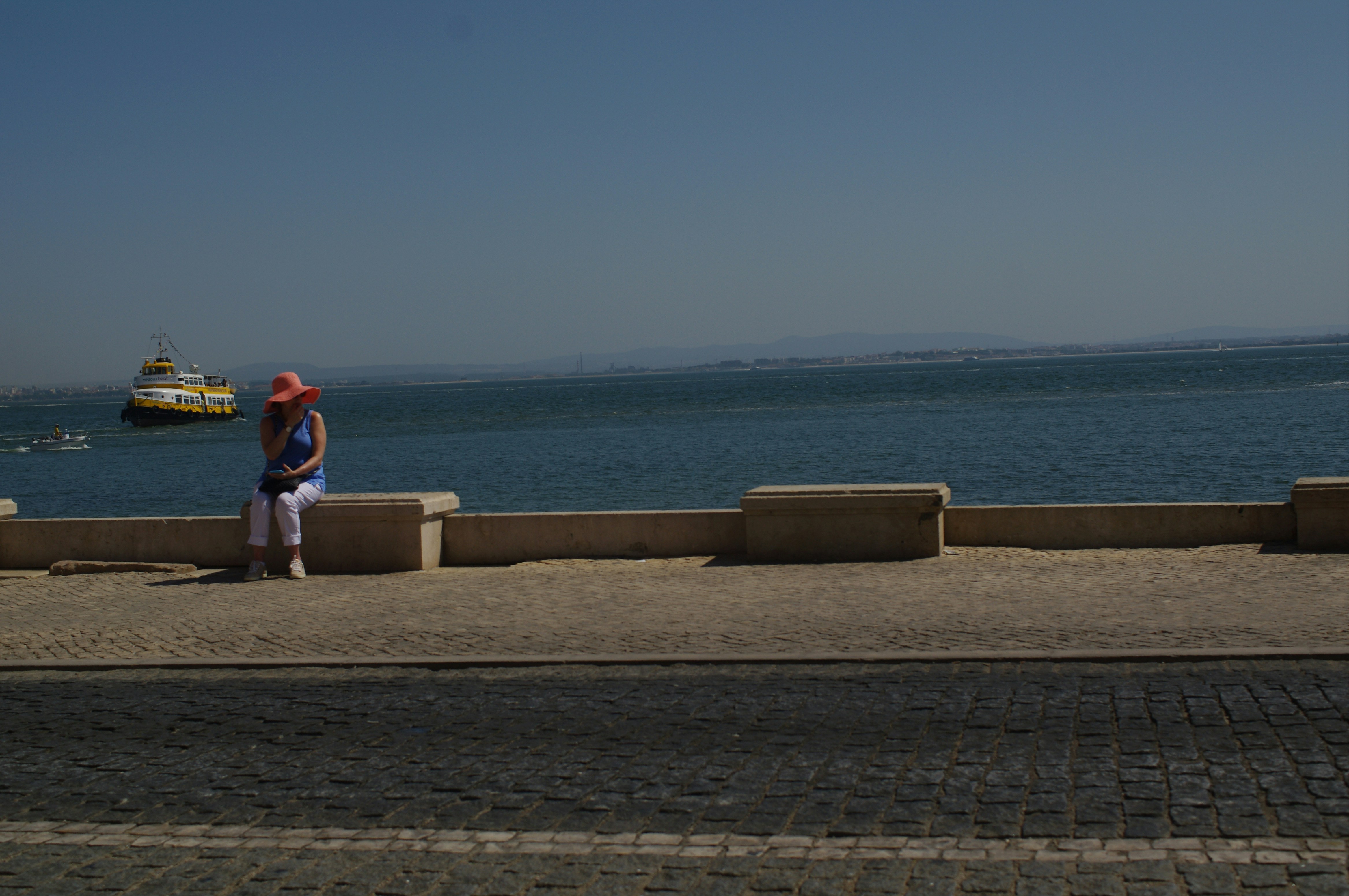 Un uomo, in piedi, sul lato di una strada, vicino all'oceano