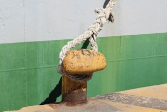 A yellow fire hydrant with a rope attached to it