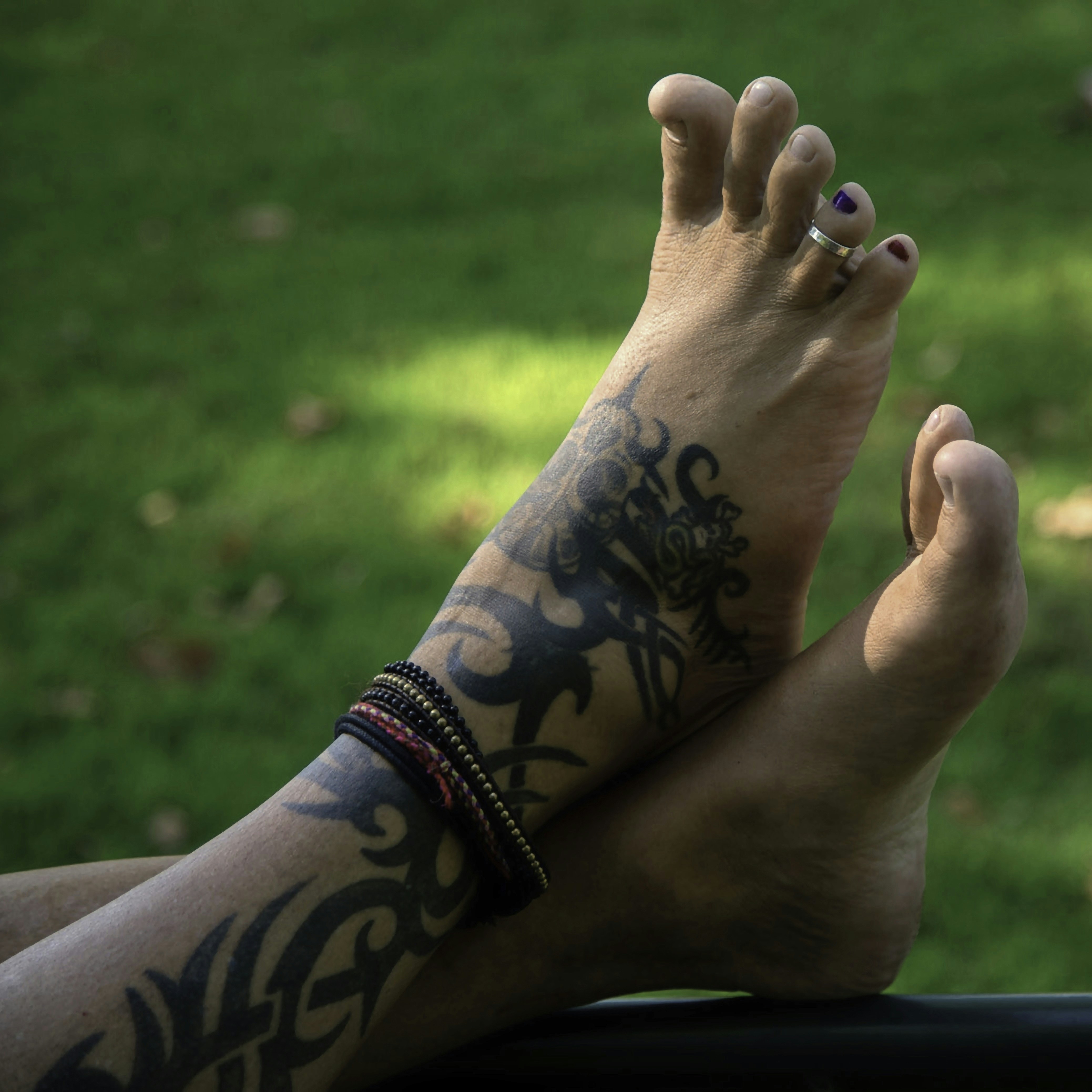 A person with tattoos on their legs sitting in a car