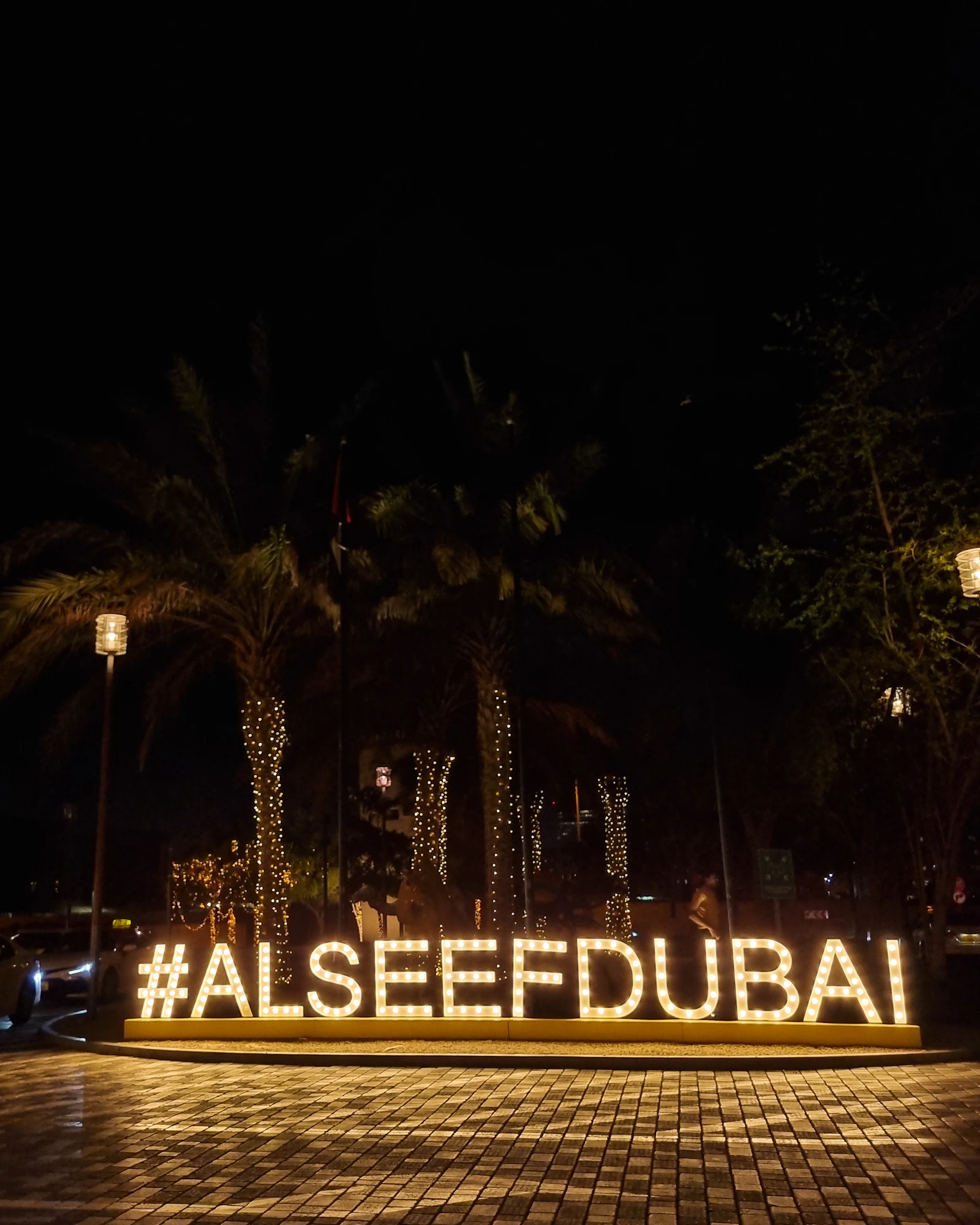 Illuminated #ALSEEFDUBAI sign at Al Seef on Dubai Creek at night